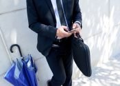 unrecognizable-businessman-with-briefcase-umbrella-standing-outdoors-using-smartphone(2)
